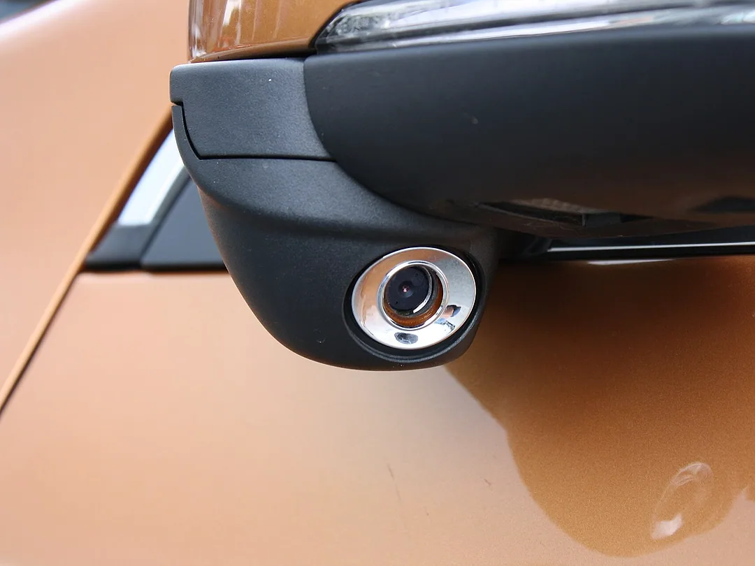 A small camera under a side mirror that watches the blind spot