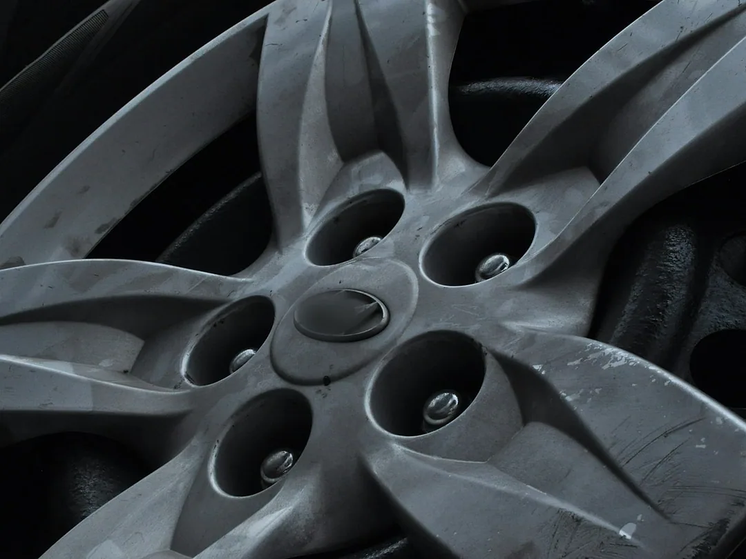 A silver five-spoke wheel cap on a car's wheel