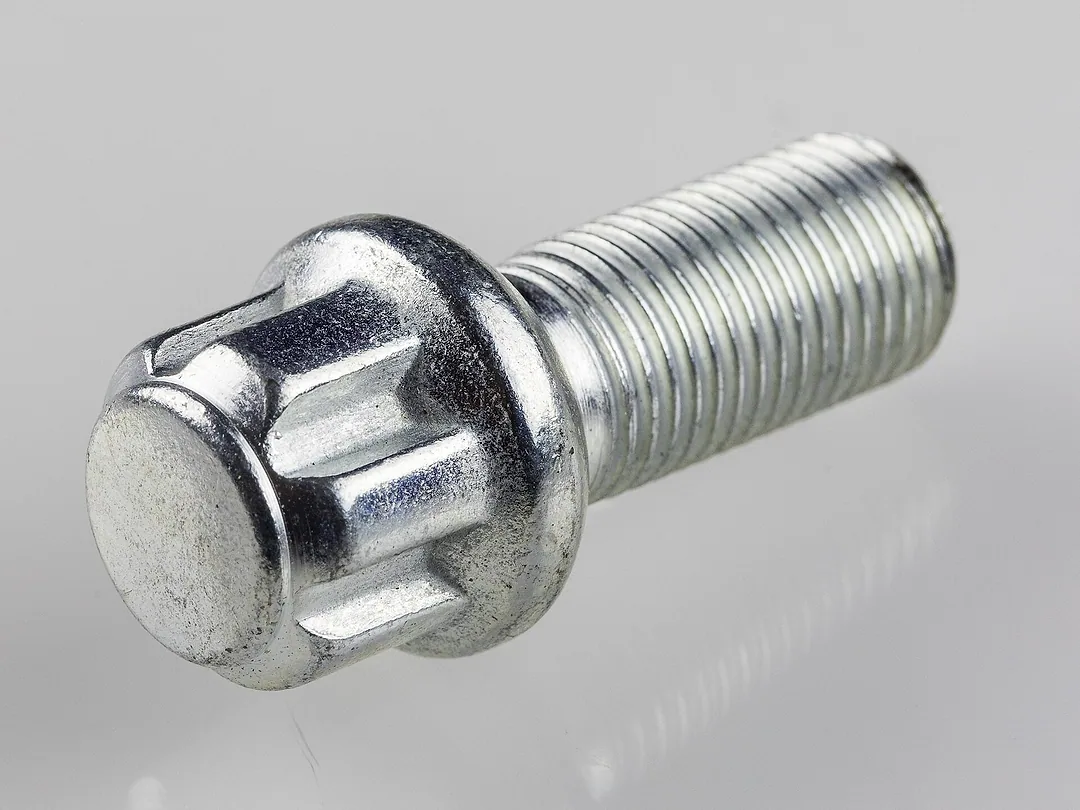 A wheel lock bolt with its patterned head, on grey